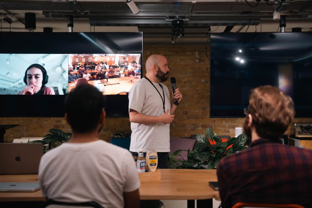 A business presentation featuring a speaker and interactive video call in an office setting.